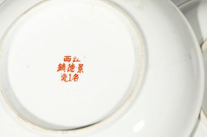 null Deux assiettes en porcelaine à décor floral et idéogramme sur fond jaune. Chine,...