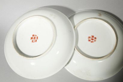 null Deux assiettes en porcelaine à décor floral et idéogramme sur fond jaune. Chine,...