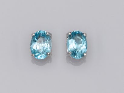 null Pair of 750°/00 (18K) gold chips each set with an oval blue topaz of about 0.90...