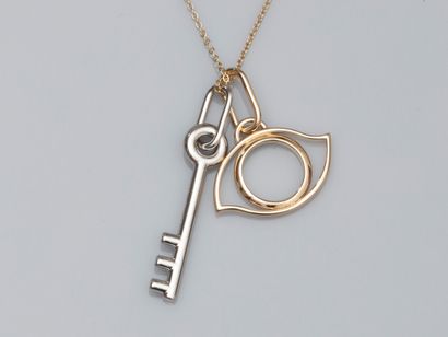 null HERMES, key pendant in palladium-plated metal, and gold-plated eye pendant signed....