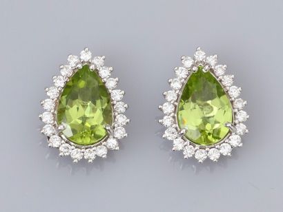 null Pair of 18K white gold earrings, each set with a pear cut peridot of approximately...