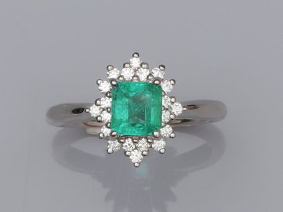 null Platinum ring set with a square faceted emerald of about 0.75 ct, surrounded...