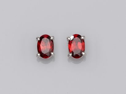 null Pair of 750°/00 (18K) gold chips each set with an oval garnet of about 0.5 ct....