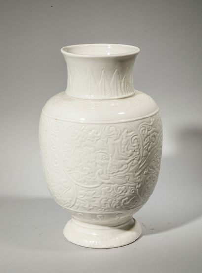 null CHINE. Vase en porcelaine blanche à décor moulé feuilles et de fleurs stylisées....