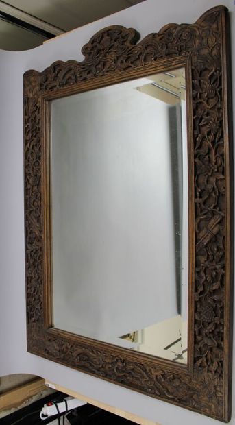 null Indochine. Grand miroir à encadrement en bois richement sculpté et ajouré à...