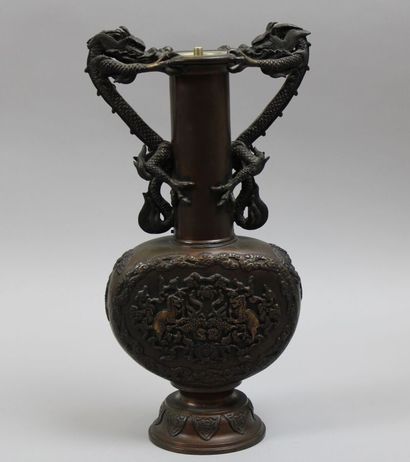 null Chine. Vase à haut col en bronze à patine brune à décor en relief sur les deux...