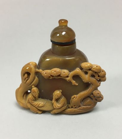 null An agate snuff bottle carved with two players under a tree. China, 20th century....