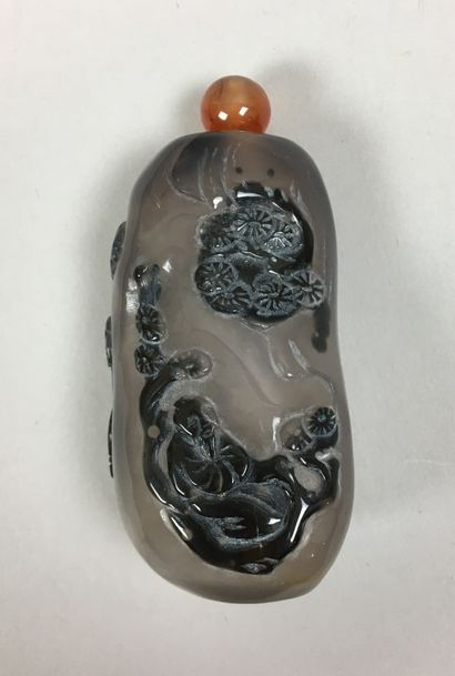 null An agate snuff bottle carved with two figures in a landscape. China, 20th century....