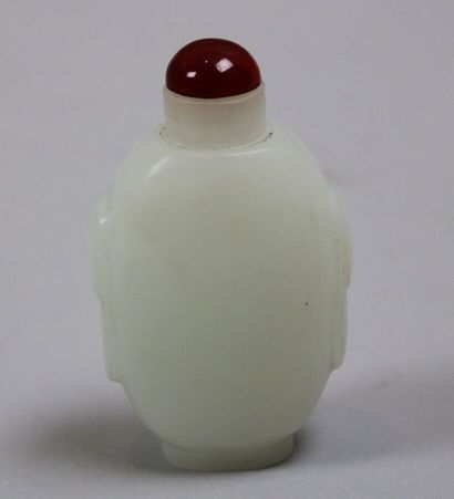 null White glass paste snuff bottle decorated with two taotie heads, imitating opaline....