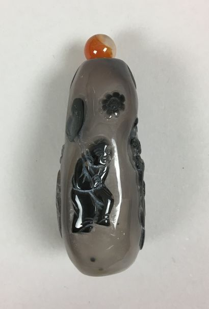 null An agate snuff bottle carved with two figures in a landscape. China, 20th century....