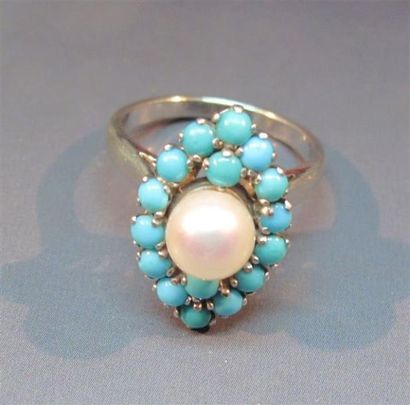 null Bague navette en or gris sertie de turquoises et centrée d'une perle de culture....