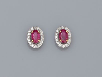 null Pair of oval earrings in two-tone 18K gold, each set with an oval ruby weighing...