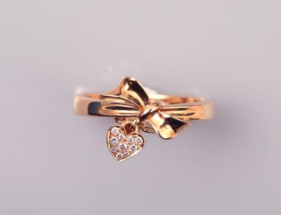 null Ring in 18K pink gold, decorated with a knotted ribbon and a heart set with...