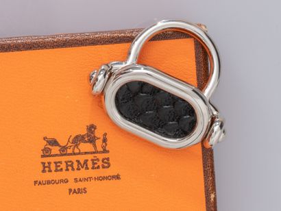 null HERMES, bague à chaton ovale basculant en métal palladié et cuir noir. Signée...