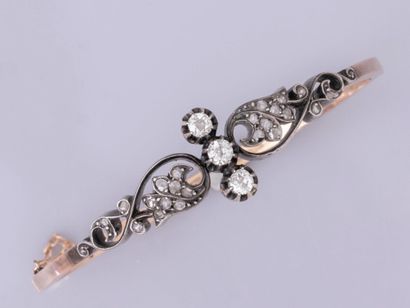 null Bracelet rigide ovale en or 750°/°° (18K) et argent 800, à décor de trois diamants...