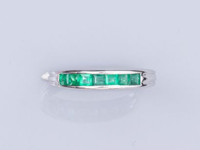 null Half wedding ring in 18K white gold, set with calibrated emeralds on the quarter...