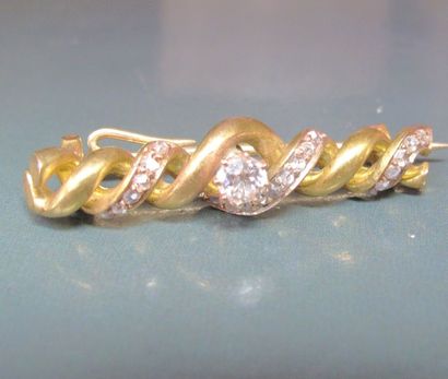 null Broche torsadée en or jaune 585°/00 (coquille), centrée d'un diamant taille...