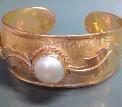 null Bracelet ouvert en or jaune 750°/00 (hibou) serti d'une demi perle de culture...