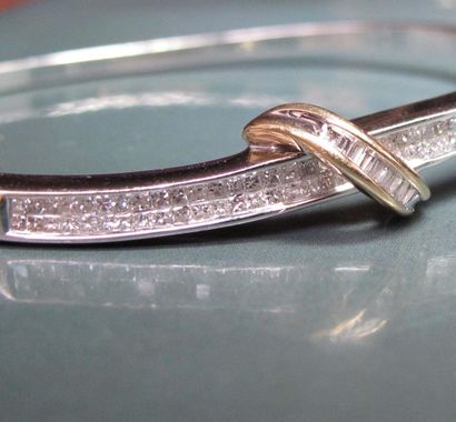 null Bracelet rigide ovale en or gris 585°/00 serti de diamants taillés en baguettes...