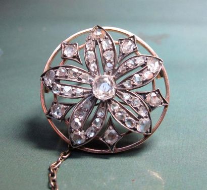   Broche ronde en or 750°/00 et argent, sertie de diamants taille ancienne et taillés...