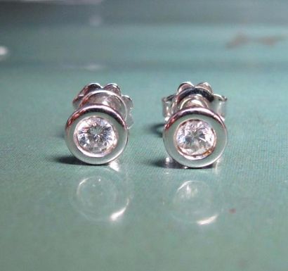   Paire de boucles d'oreilles en or gris 750°/00, chacune est sertie d 'un diamant...
