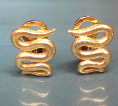   Paire de boucles d'oreilles clips en or jaune martelé 750°/00, stylisent des serpents....