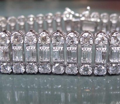   Important bracelet en or gris 750°/00 , serti de diamants baguettes entre deux...