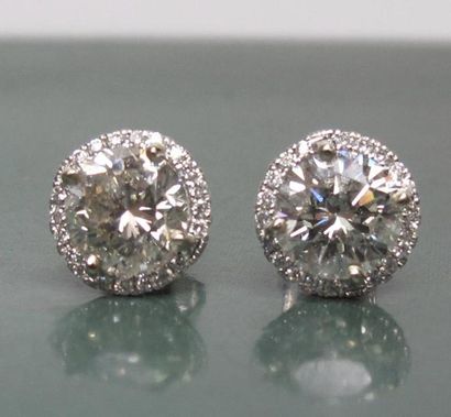   Boucles d'oreilles en or gris 750°/00, chacune est sertie d 'un diamant taille...