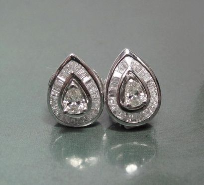   Paire de boucles d'oreilles en or gris 750°/00 serties chacune d'un diamant taillé...