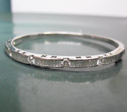   Bracelet rigide ovale serti de diamants taille brillant et taillés en baguettes...
