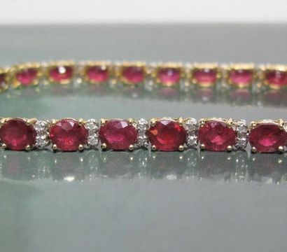   Bracelet en or deux tons 750°/00 , serti de rubis ovales à facettes pour 14 carats...
