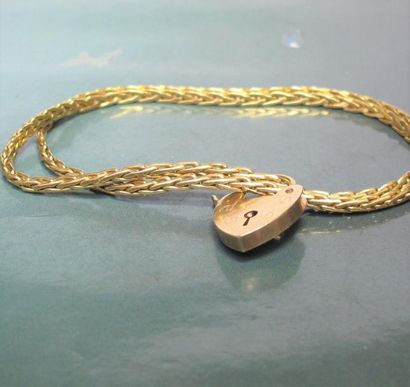   Deux bracelets en or jaune 750°/00, maille tressée reliés par un petit cadenas...
