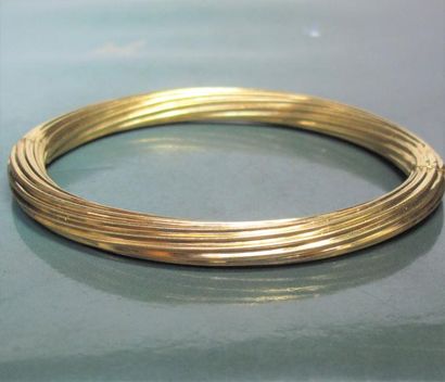   Bracelet rigide ovale en or jaune 750°/00 torsadé. Ouvre à charnière. 21.60 g....