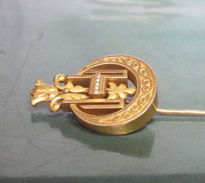   Epingle de cravate en or jaune 750°/00, ciselée à décor d'une lyre et feuillages....