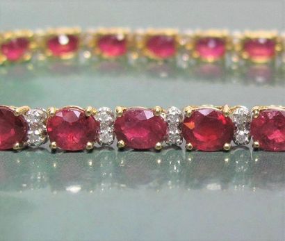   Bracelet en or deux tons 750°/00 , serti de rubis ovales à facettes pour 14 carats...
