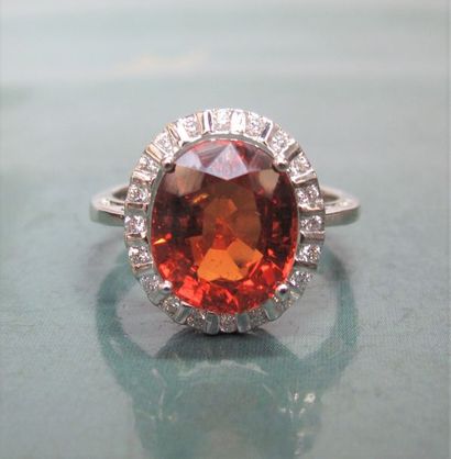   Bague en or gris 750°/00 sertie d'un grenat orange spessartite, ovale de 5.50 carats...