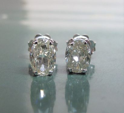   Paire de boucles d'oreilles en or gris 750°/00, serties chacune d'un diamant ovale...