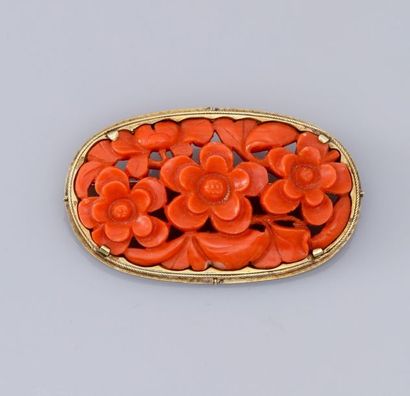   Broche ovale en or jaune 585°/00, sertie de corail sculpté à décor de fleurs. 10.30...