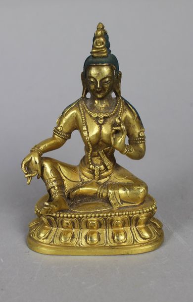null Bouddha en bronze doré assis en position de l’argumentation, genou droit relevé....