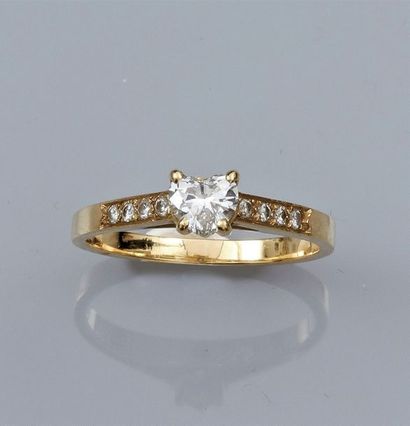   Bague en or jaune 750°/00 (18K), sertie d'un diamant taillé en cœur, épaulé de...