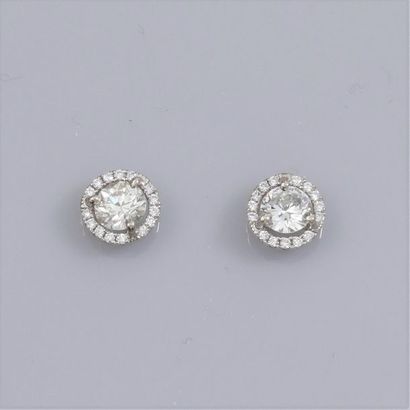   Paire de boucles d'oreilles en or gris 750°/00 (18K), chacune est sertie d'un diamant...