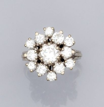  Bague fleur en or gris 750°/00 (18K) fileté, sertie d'un diamant taille brillant...