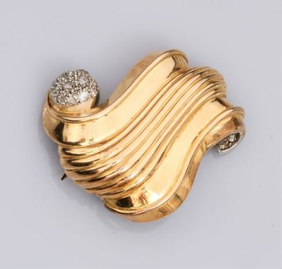   Broche clip volute en or jaune 750°/00 (18K)et platine, sertie de diamants taille...