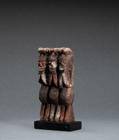  Figurine « Kiké » 
présentant trois personnages, leur tête évoquant le loup et symbolisant...