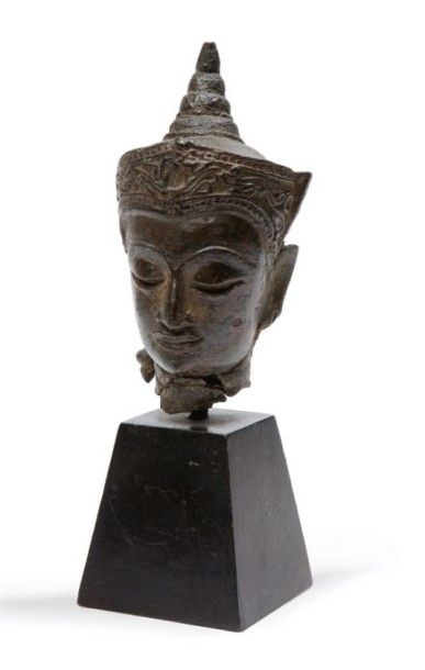 Siam, XVIe siècle 
Petite tête de Bouddha paré en bronze de patine brune avec traces...