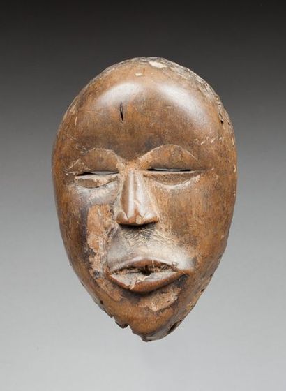 Masque de danse sculpté d'un visage à l'expression...