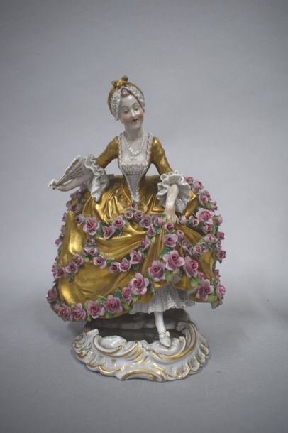 null Statuette porcelaine représentant une femme en robe à crinoline à fond doré,...