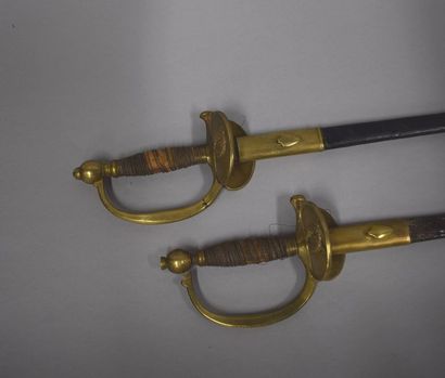  Deux épées d'officier modèle 1872 toutes armes. Fourreau en cuir accidenté. 
 
