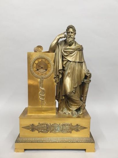 null Pendule en bronze doré et ciselé, le cadran à chiffres romains dans une borne...