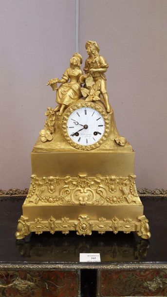 null Gilded bronze clock surmounted by a group representing a gallant couple, 

the...